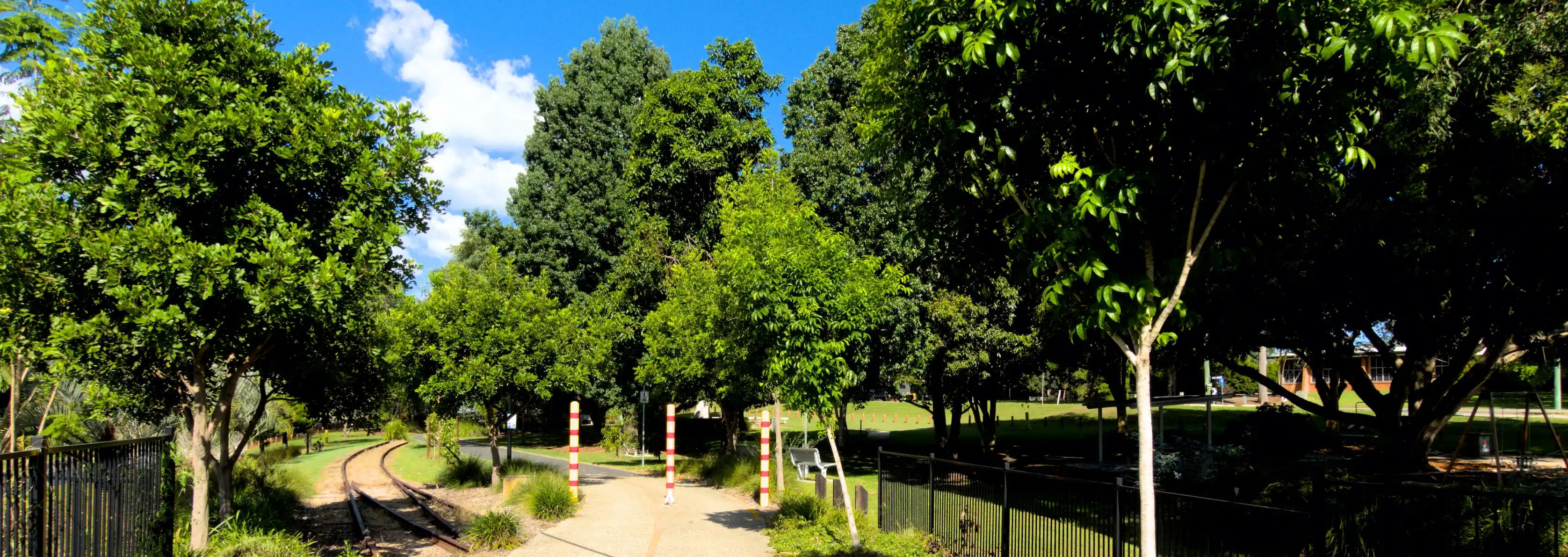 The Wamuran end of the Wamuran Rail Trail. The path goes past a park into the distance while the old rails terminate at a footpath.