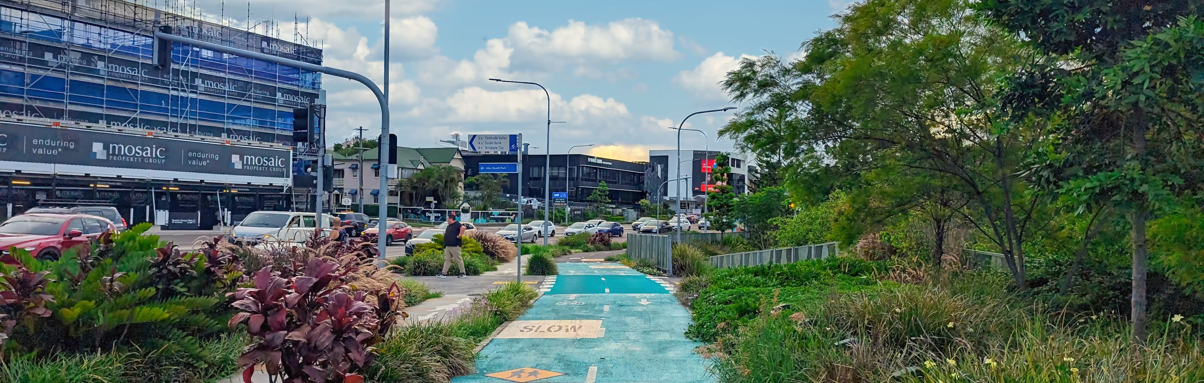 The bikeway runs alongside Lytton road. There's lots of plants and greenery, and a pedestrian crossing coming up ahead.