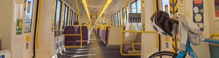 A blue bike in a mostly empty train carriage