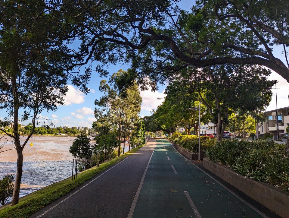 The Centennial bikeway, shaded under lush trees, the chocolate river to the left