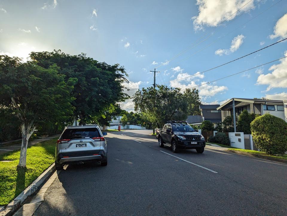 A street with no shoulder, a bit of traffic, and some footpaths either side