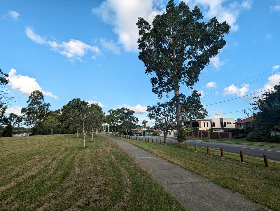 A narrow off-road bikeway runs alongside the Brisbane Corso and river