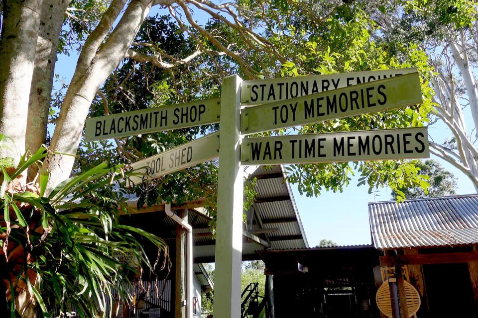 A sign pointing to blacksmith shop, tool shed, stationary engines, toy memories & wartime memories