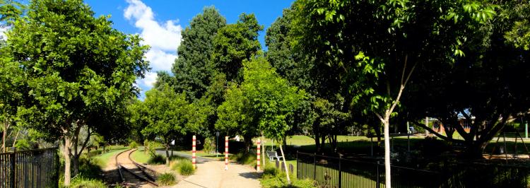 The Wamuran end of the Wamuran Rail Trail. The path goes past a park into the distance while the old rails terminate at a footpath.